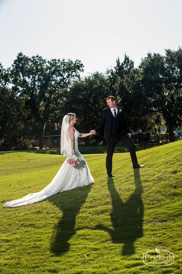 bride and groom posing on grass