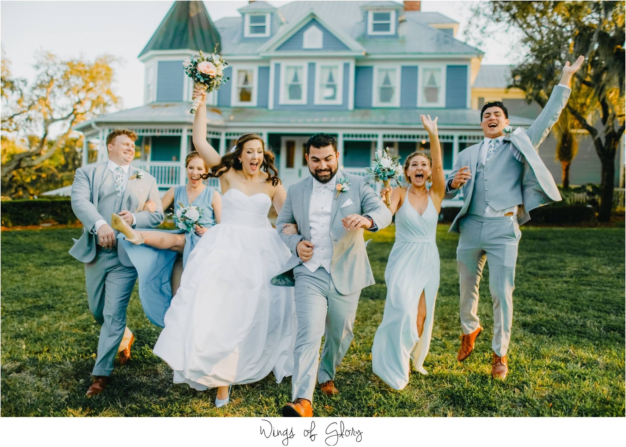 bride, groom, and wedding party posing in front of highland manor